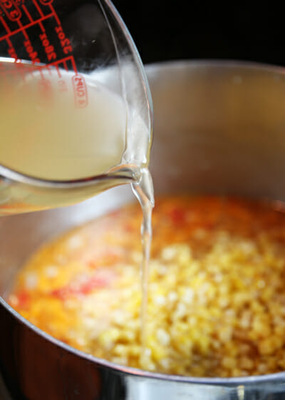 pouring broth into soup